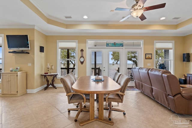 dining area featuring ceiling fan, ornamental molding, a raised ceiling, and french doors