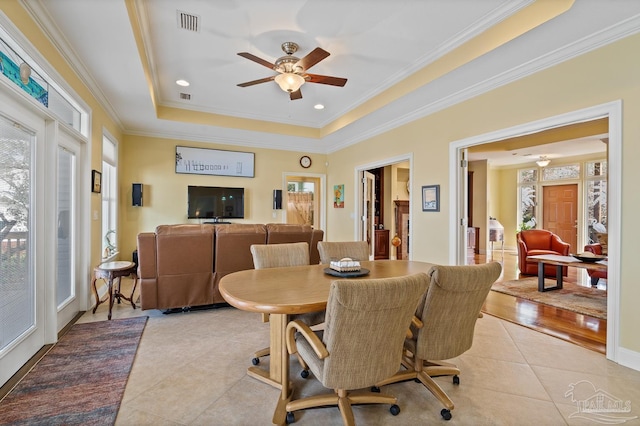 dining room with ceiling fan, light tile patterned flooring, crown molding, and a raised ceiling