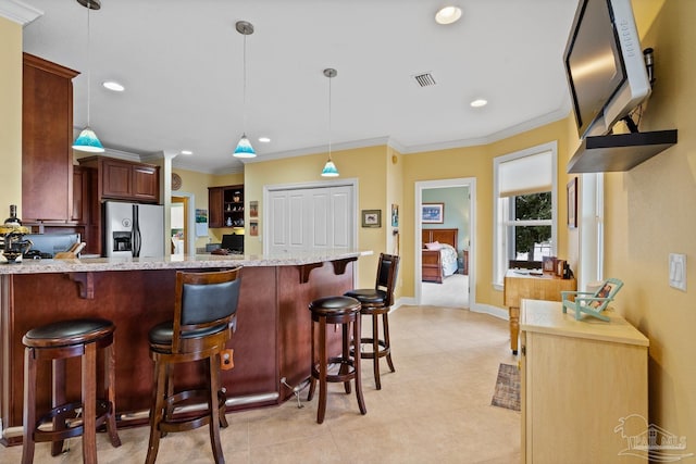 kitchen featuring hanging light fixtures, stainless steel fridge with ice dispenser, kitchen peninsula, crown molding, and a breakfast bar area