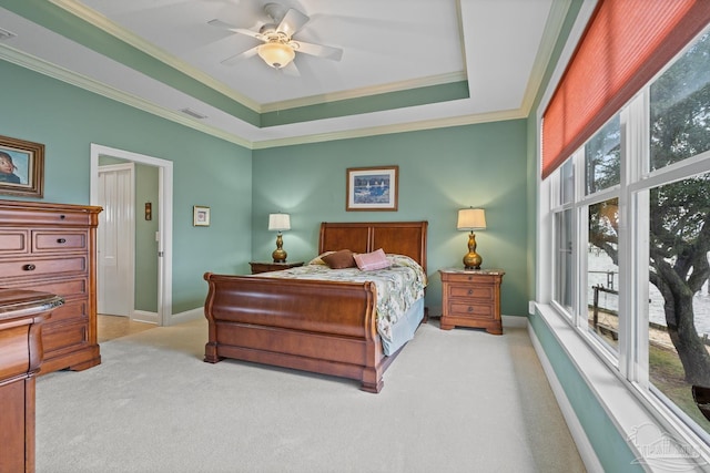 bedroom featuring ceiling fan, crown molding, light carpet, and a raised ceiling