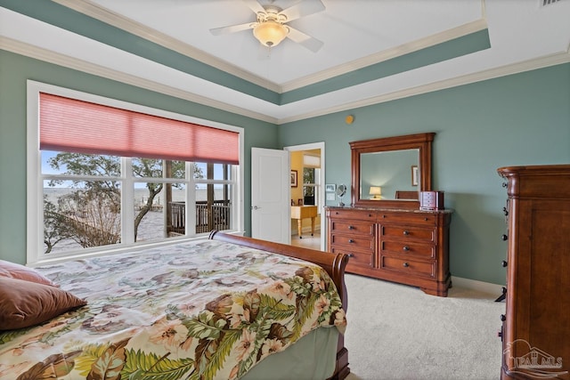 carpeted bedroom featuring ceiling fan, crown molding, and a raised ceiling