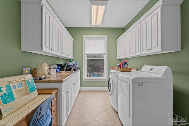 laundry room featuring cabinets, light tile patterned floors, and independent washer and dryer