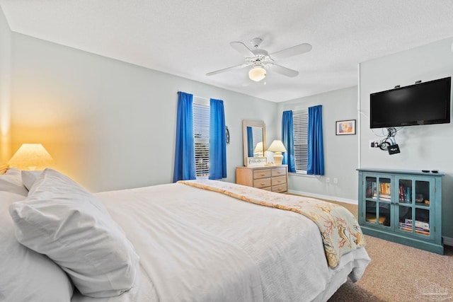 carpeted bedroom featuring ceiling fan and a textured ceiling