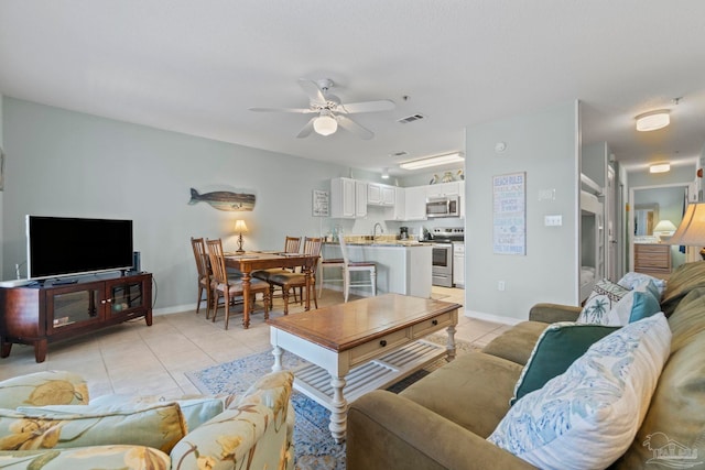 tiled living room featuring sink and ceiling fan