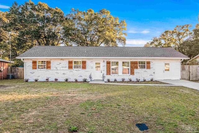 ranch-style home featuring central air condition unit and a front lawn