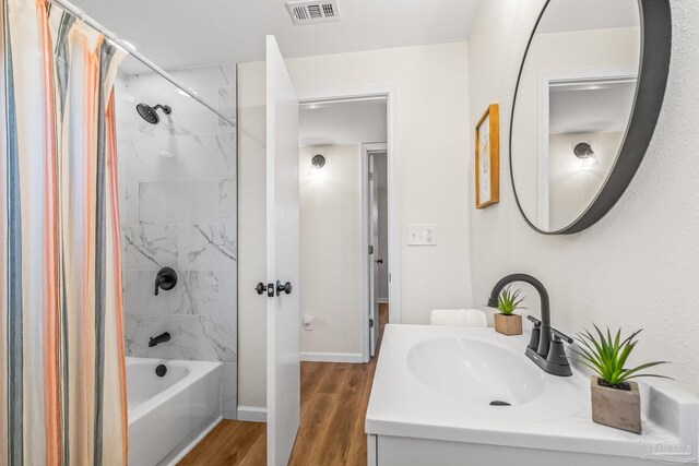 bathroom featuring vanity, hardwood / wood-style flooring, and shower / bath combo with shower curtain