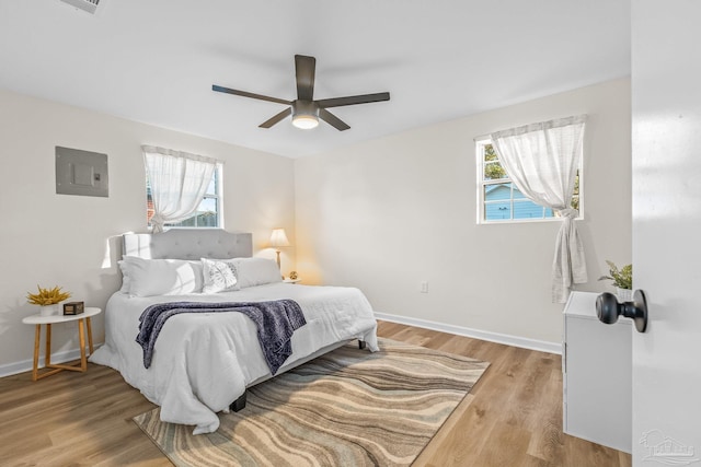 bedroom featuring hardwood / wood-style floors, electric panel, and ceiling fan