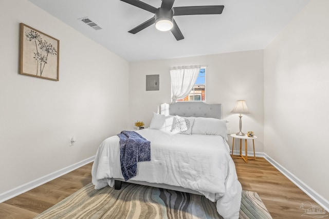 bedroom featuring hardwood / wood-style flooring, ceiling fan, and electric panel