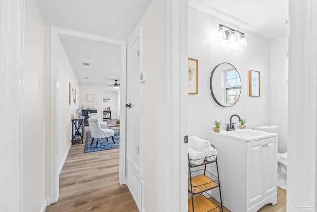 bathroom featuring ceiling fan, vanity, wood-type flooring, and toilet