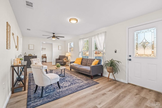 living room with ceiling fan and light hardwood / wood-style flooring