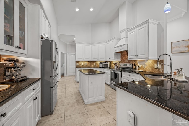 kitchen with light tile patterned floors, white cabinets, dark stone counters, appliances with stainless steel finishes, and a sink