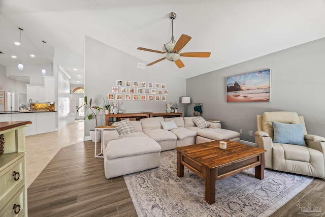 living area featuring light wood-style floors, recessed lighting, ceiling fan, and high vaulted ceiling