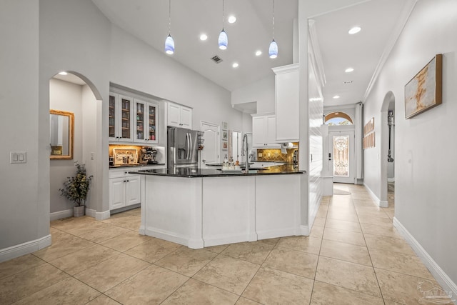 kitchen with dark countertops, glass insert cabinets, light tile patterned flooring, white cabinetry, and stainless steel fridge with ice dispenser