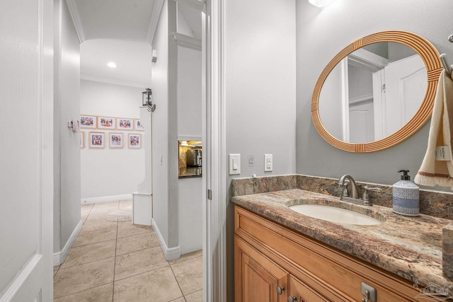 bathroom featuring crown molding, vanity, baseboards, and tile patterned floors