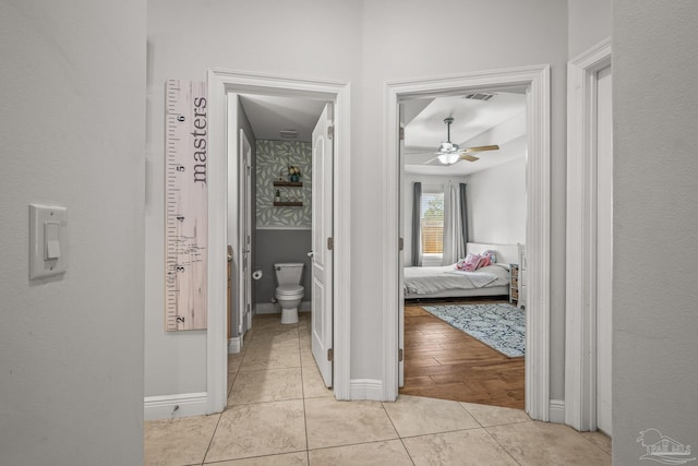 hallway with light tile patterned flooring and baseboards