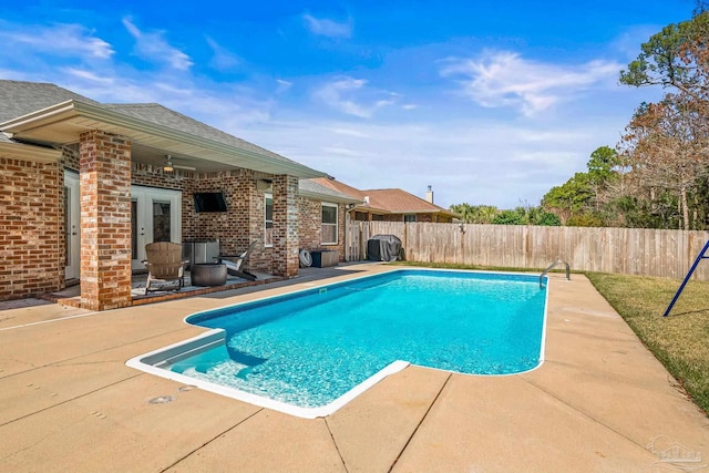 view of swimming pool with a patio, french doors, a fenced backyard, and a fenced in pool