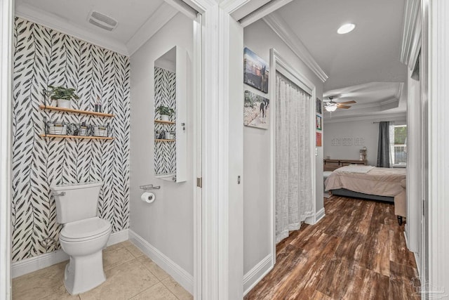 bathroom featuring toilet, baseboards, wallpapered walls, ensuite bath, and crown molding