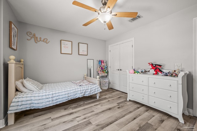 bedroom with light wood finished floors, a closet, visible vents, and a ceiling fan