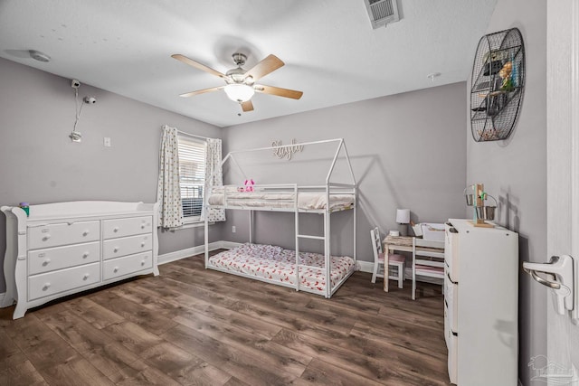 bedroom featuring baseboards, visible vents, and wood finished floors