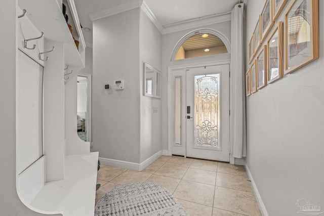 entrance foyer featuring ornamental molding, light tile patterned flooring, and baseboards