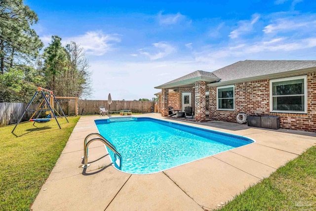 view of pool featuring a fenced in pool, a lawn, a fenced backyard, a patio area, and a playground