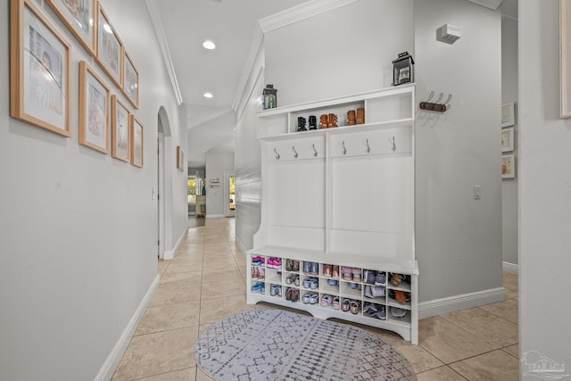 mudroom with arched walkways, light tile patterned floors, recessed lighting, baseboards, and crown molding