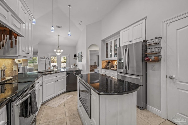 kitchen with arched walkways, white cabinets, dishwasher, stainless steel fridge with ice dispenser, and a sink