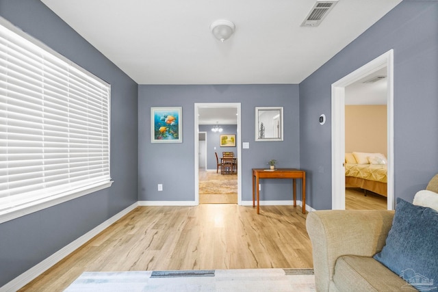 sitting room with hardwood / wood-style floors and an inviting chandelier