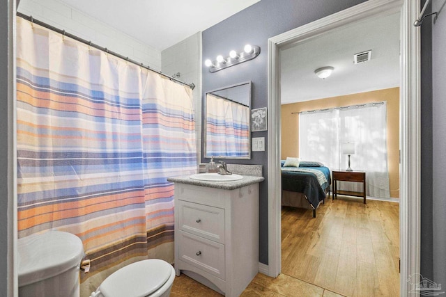 bathroom featuring wood-type flooring, vanity, and toilet