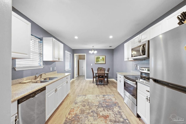 kitchen featuring light hardwood / wood-style flooring, white cabinets, stainless steel appliances, and sink