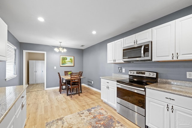 kitchen with white cabinetry, stainless steel appliances, an inviting chandelier, light hardwood / wood-style flooring, and decorative light fixtures