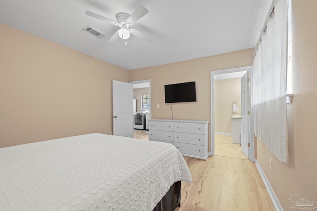 bedroom with ceiling fan, washer / clothes dryer, and light hardwood / wood-style flooring