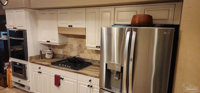 kitchen with decorative backsplash, white cabinetry, stainless steel appliances, and light stone counters