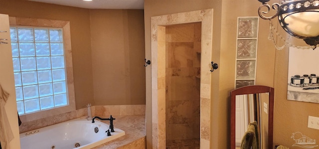 bathroom with a whirlpool tub and a tile shower