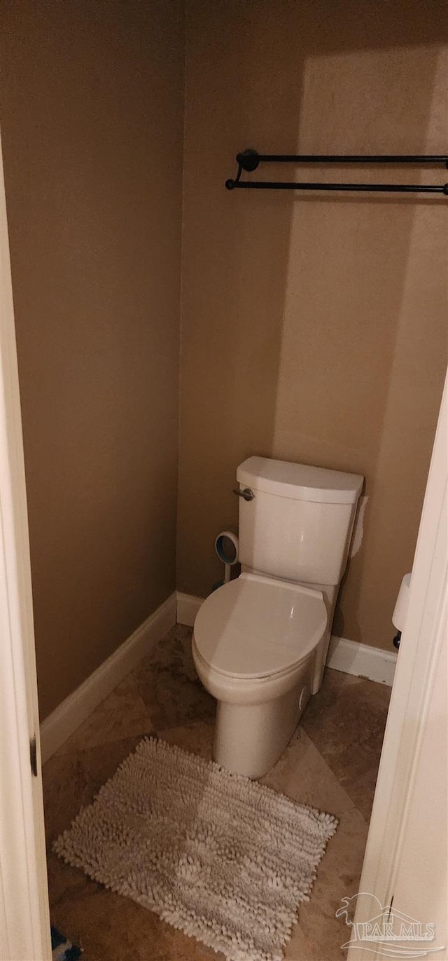 bathroom with baseboards, toilet, and tile patterned floors