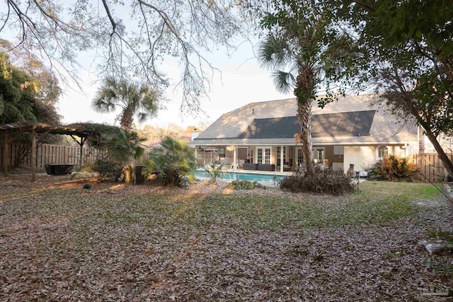 back of property with a patio, fence, a fenced in pool, and a pergola