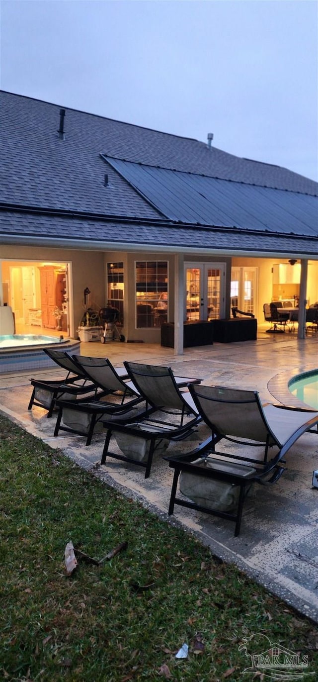 back of property with an outdoor hangout area, a swimming pool, outdoor dining area, a shingled roof, and a patio area
