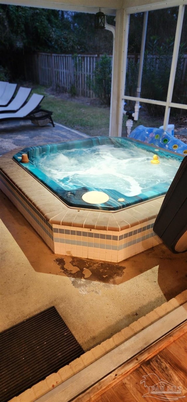 exterior details featuring a hot tub and fence