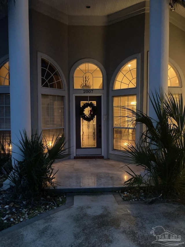 doorway to property with stucco siding and a porch