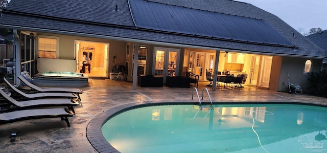 outdoor pool with a patio, outdoor dining area, and french doors