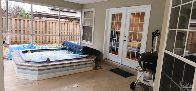 view of patio featuring area for grilling, fence, french doors, and an outdoor hot tub