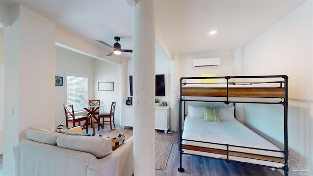 bedroom with hardwood / wood-style flooring, a wall mounted air conditioner, and ceiling fan