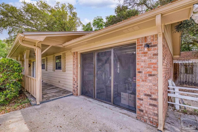 exterior space featuring brick siding and a patio area