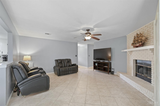 living area with baseboards, visible vents, a ceiling fan, a fireplace, and light tile patterned floors