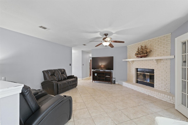 living area with a fireplace, visible vents, a ceiling fan, and light tile patterned floors