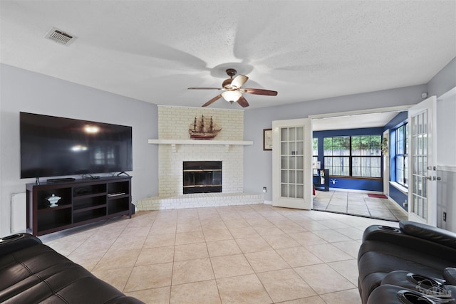 living room featuring tile patterned floors, french doors, a textured ceiling, visible vents, and ceiling fan