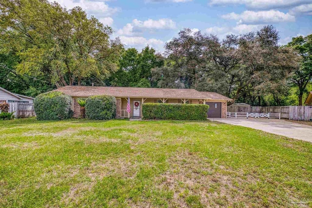 single story home with an attached garage, a front yard, concrete driveway, and fence