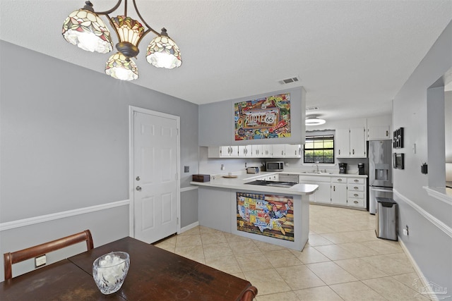 kitchen with a sink, stainless steel appliances, light countertops, a peninsula, and visible vents