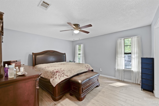 bedroom with light wood-type flooring, visible vents, and multiple windows