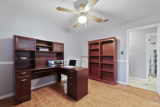 office space featuring light wood-style floors, visible vents, a ceiling fan, and baseboards